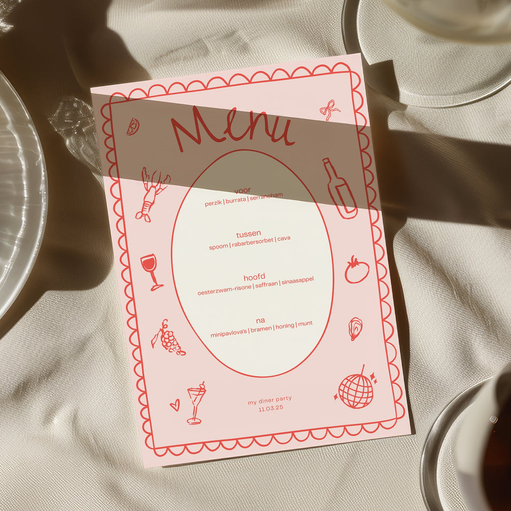 Pink hand-drawn dinner party menu card on a white tablecloth in the sun
