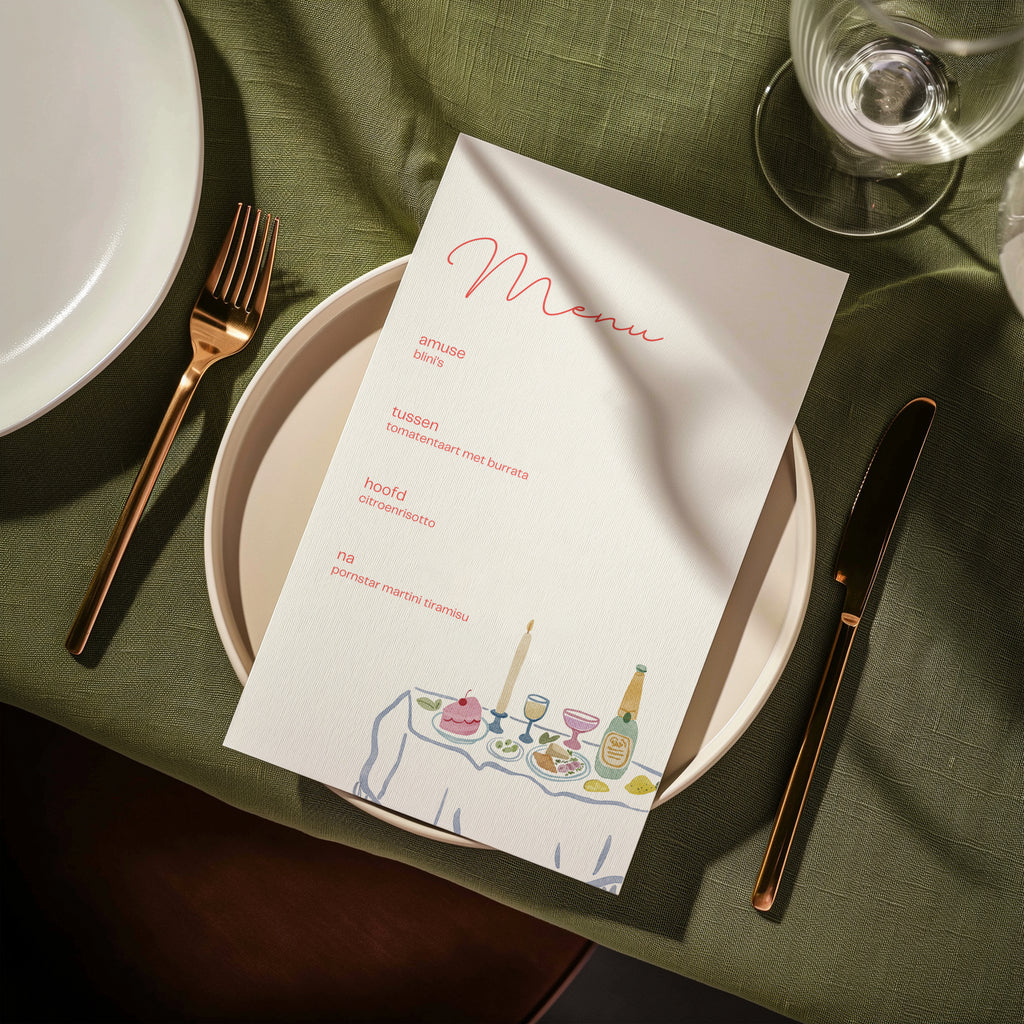 Dinner party menu card on a plate with green table linen and gold cutlery